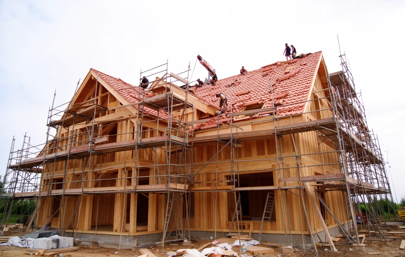 New timber frame house with scaffolding while the roof is being finished